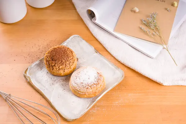 Tabağa konmuş Choux kremi, kahverengi ahşap arka plan.