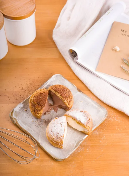 Tabağa konmuş Choux kremi, kahverengi ahşap arka plan.