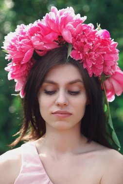Beautiful young girl with peonies