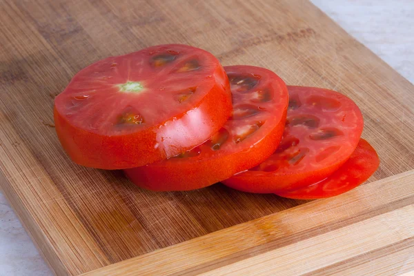 Świeżo slised pomidor na pokładzie cięcia drewnianych — Zdjęcie stockowe