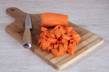 Ahşap kesme tahtası üzerinde doğranmış havuç