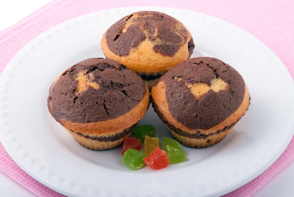 Beyaz bir plaka üzerinde üç lezzetli muffins