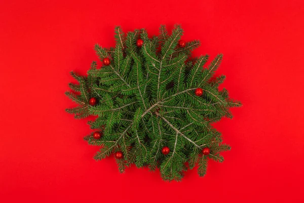 Vista superior de fondo redondo de Navidad con ramas de abeto y decoraciones sobre fondo rojo. Espacio para texto. —  Fotos de Stock
