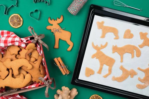 Vista superior de galletas de jengibre navideño de masa cruda en bandeja para hornear, jengibre fresco, canela, galleta perfiladora de ciervos, galletas recién respaldadas. — Foto de Stock