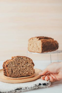 İki dilim taze muz ve ahşap masanın üzerinde gri peçete üzerinde yulaflı ekmek..