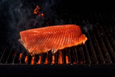 Somon balığı fileto alevli ızgarada pişiyor dumanla..