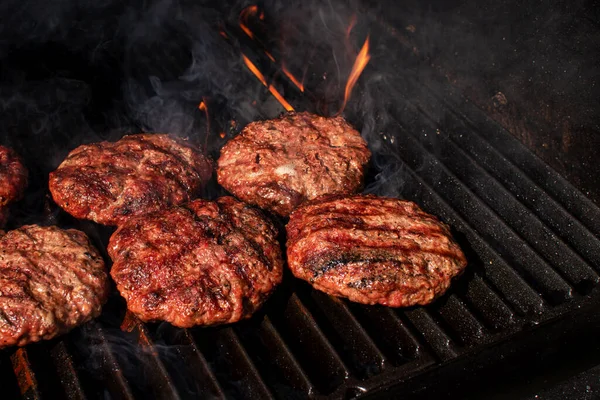 Alta visão de anjo carne caseira hambúrgueres churrasco rissóis para hambúrguer cozinhar em churrasco grill flamejante. — Fotografia de Stock
