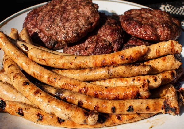 Saucisses BBQ rôties avec grillades et hamburgers BBQ de viande maison grillée pour hamburger sur assiette. — Photo