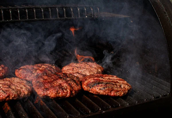 Domácí maso BBQ hamburgery placky na hamburger vaření na hořícím grilu grilování. — Stock fotografie