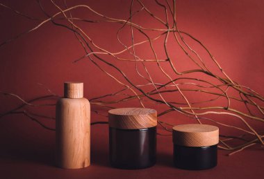 Ahşap ve cam şişelerin ön görüntüsü boş etiketler kırmızı üzerinde cilt kozmetik ürünler için model 