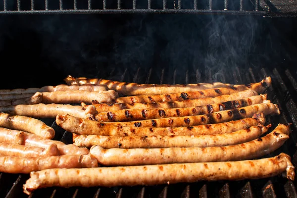 Saucisses rôties avec grillades cuisson sur barbecue grill avec fumée. — Photo