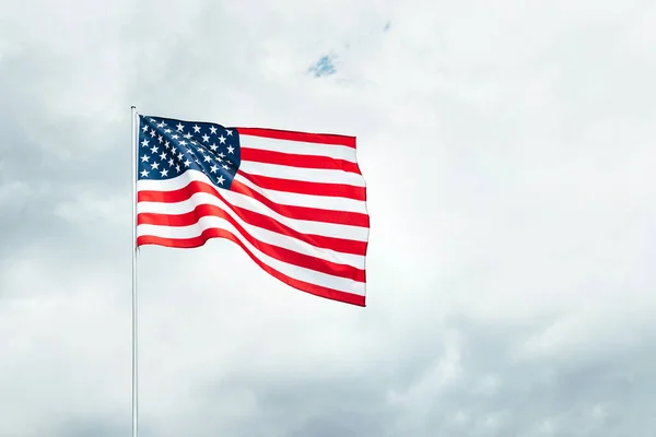 미국, 구름낀 하늘 위에서 바람에 흔들 리는 미국 국기. 로열티 프리 스톡 이미지