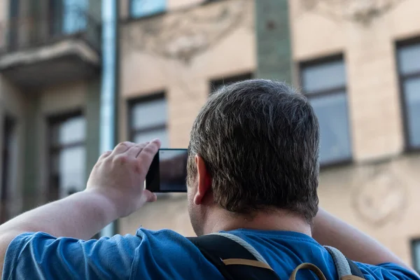 Man Blue Shirt Takes Photos Old Building His Phone View — Zdjęcie stockowe