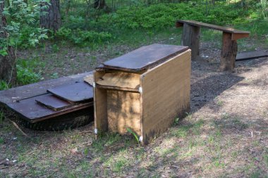 an old folding table in the forest. the concept of environmental pollution
