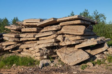 a pile of old concrete slabs with protruding fittings