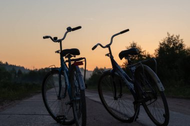two bicycles on the background of a beautiful sunset sky in spring. the concept of love