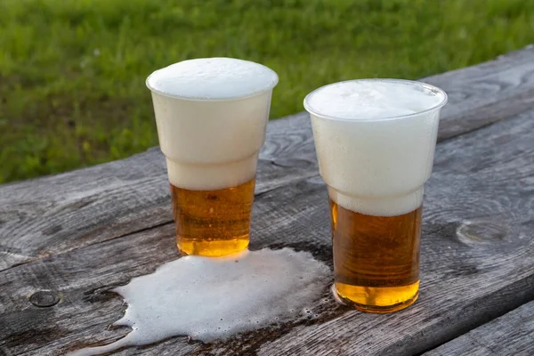 Two Clear Plastic Glasses Beer Wooden Table Background Green Grass — Foto de Stock