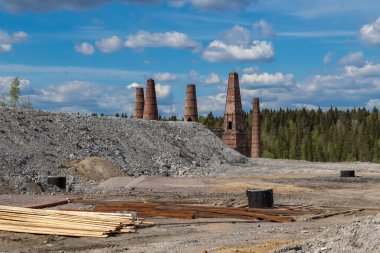 Baharda mermer kanyonda ormanın arka planına karşı yeni bir otel inşaatı. Arka planda kırmızı eski tuğla bacalar