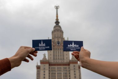 Moskova, Rusya - 12 Eylül 2021: Moskova Devlet Üniversitesi 'nin arka planında iki öğrenci kimliği