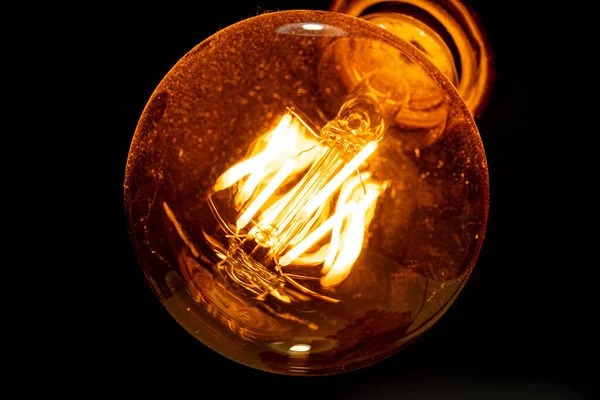 Decorative carbon filament bulb light. Dust on the glass. Macro photography.