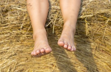Samanlıkta sallanan çocuk ayaklarının yakın çekimi 