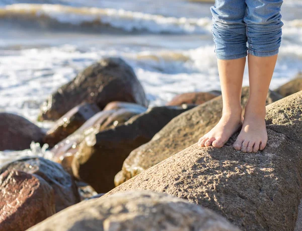 Çocuğun Çıplak Ayakları Deniz kenarındaki Kayalıkta Duruyor.