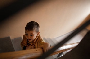 Girişteki beş yaşındaki bir çocuk merdivenlerden yukarı çıkıyor.