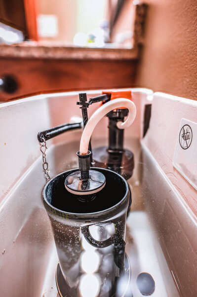 Water level view of internal workings of a sanitary toilet with fill and float mechanisms.