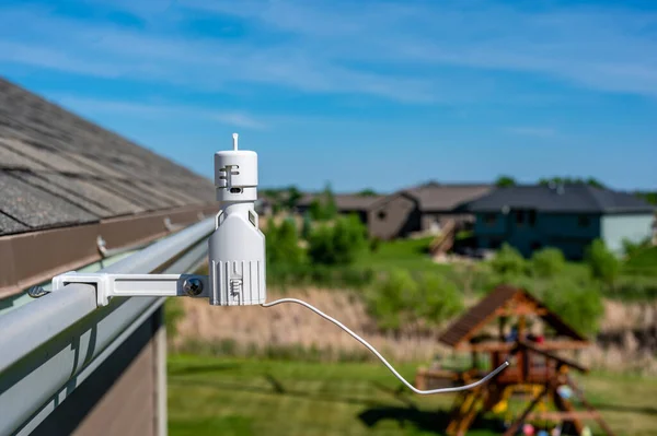 Wireless sprinkler rain sensor used to conserve water. Device is installed on a residential roof gutter