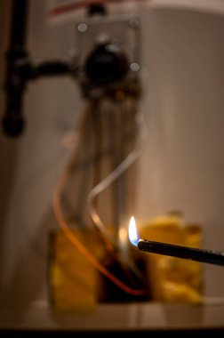 Sıcak su ısıtıcısını ateşlemek için çakmak kullanmış.