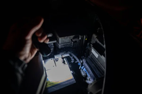 Перевірка батареї під витяжкою з ліхтариком вночі — стокове фото