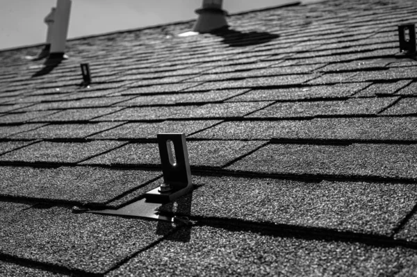 住宅沥青路面屋盖，装有金属锚，用于安装太阳能板轨道和车削系统 — 图库照片