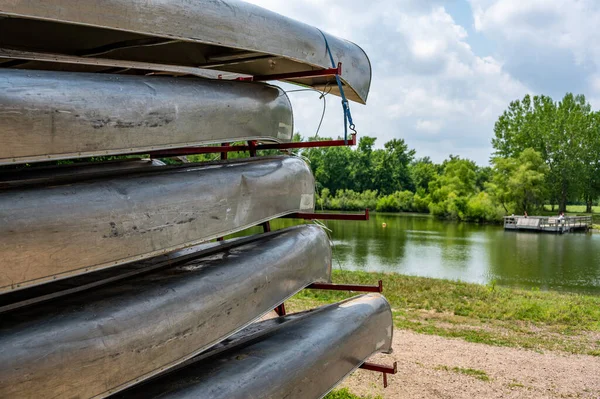 Aluminium kanoter staplade på en släpvagn med en strand front och öppet vatten i bakgrunden — Stockfoto