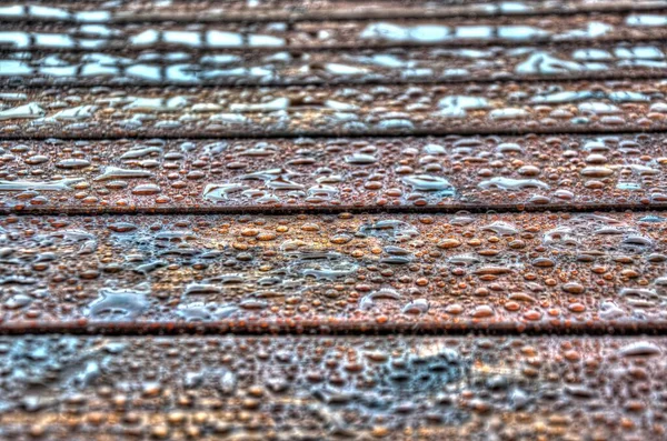 Water beading up on a freshly stained wooden deck