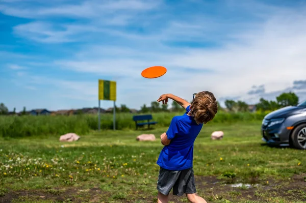 Кавказька дитина грає в диск-гольф і робить перше кидання — стокове фото