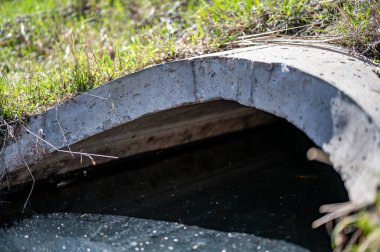 Tam kapasite beton menfez. Parlak kirlenmiş fırtına suyu akıyor.