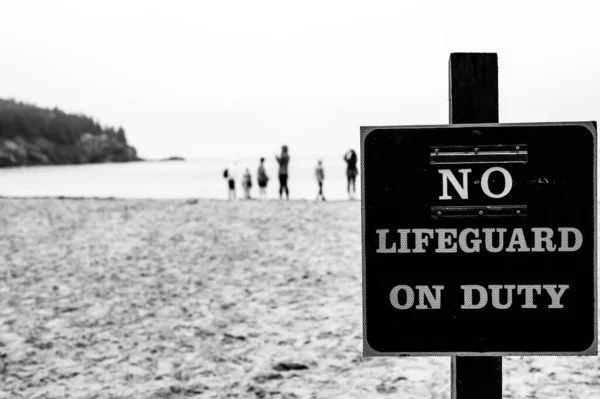 Cartel publicado en una playa de arena que indica No hay salvavidas en servicio — Foto de Stock