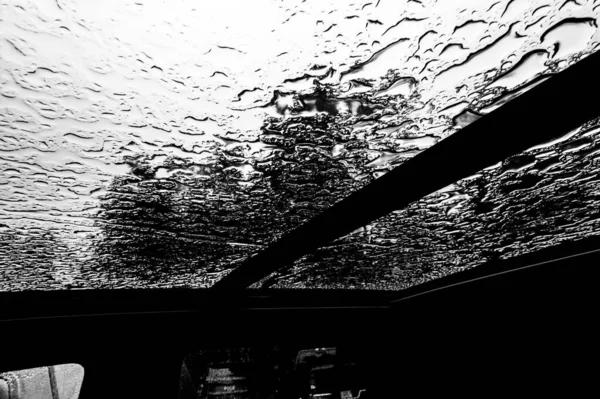 À l'intérieur d'un véhicule regardant vers un toit ouvrant avec des gouttelettes d'eau — Photo