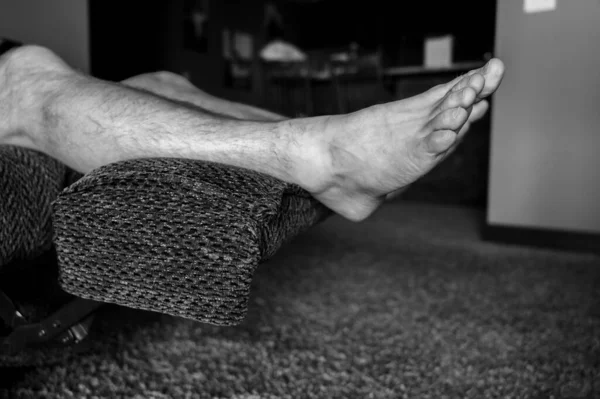 White Caucasian male with feet elevated on reclining chair — Stock Photo, Image