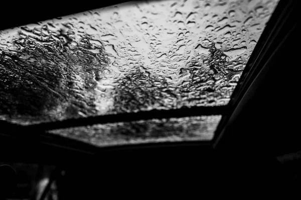 Inside a vehicle looking up to a sunroof with water droplets — Stock Photo, Image