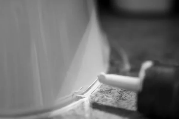 Focus selettivo sul calafatamento in silicone pronto per essere applicato attorno al sigillo di un bagno. — Foto Stock