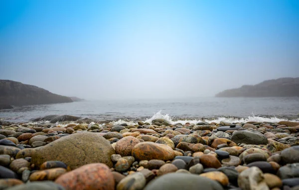 Pedras redondas multicoloridas na Little Hunters Beach, no Parque Nacional Acadia, Maine. Maré a chegar quando as ondas caem. — Fotografia de Stock