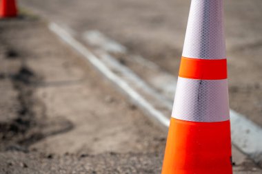 Parlak renkli trafik konisi Chicago 'da bir inşaat alanında duruyor. Koni, sürücülere bölgede devam eden çalışmalar hakkında uyarı veren açık işaretler içeriyor. Trafiğin güvenli akışını sağlar..