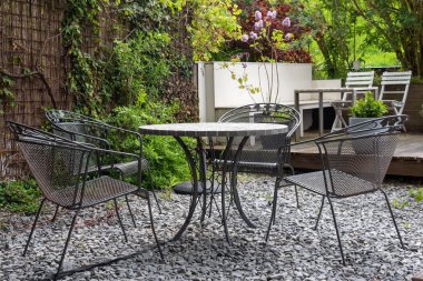 Boş masa ve arka bahçedeki sandalyeler.