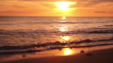 Sakin dalgalar ve altın günbatımı