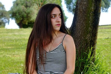 Mavi gözlü güzel kız çimenlerde yatıyor.