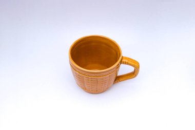 Beyaz arkaplanda örülmüş bambu motifli boş sarı-kahverengi bardak