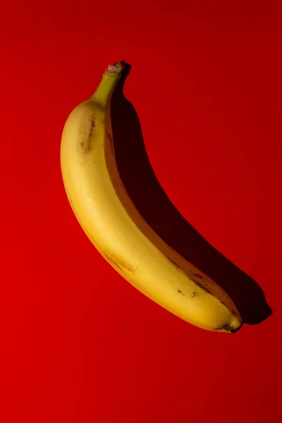 Μια Απλή Μπανάνα Κόκκινο Φόντο — Φωτογραφία Αρχείου