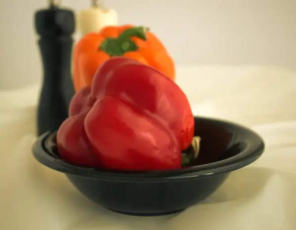 Beyaz masa örtüsünde biberli iki baharat tutacağı.