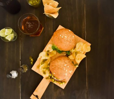 Tahtada iki hamburger, yemek ve eğlenmek için bira.